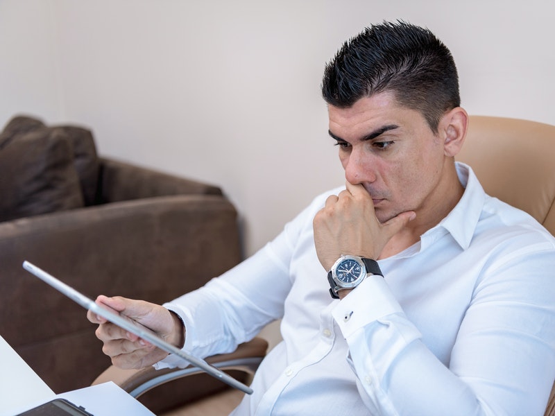 man looking at tablet with perplexed look